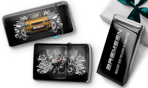 Elegante Geschenkboxen mit einem blauen Auto und einem Biker, umgeben von metallischen Zahnrädern. Eine Box trägt den Text „BREMSEN Macht Die Regeln Schmutzig“, was einen dynamischen, kantigen Ton hinzufügt.
