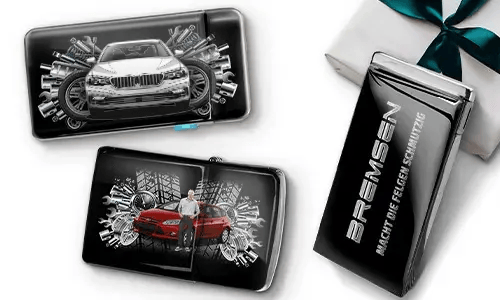 Drei elegante schwarze Geldbörsen mit Bildern von Autos und Zahnrädern, platziert neben einer Geschenkbox. Auf einer steht „Bremsen“. Das Design ist dynamisch und modern.