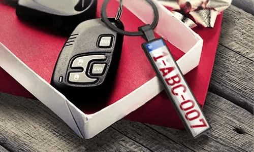 Metal license plate keychain displays engraved numbers beside car keys
