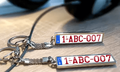 Gepersonaliseerde metalen sleutelhangers met eigen tekst en kentekenplaat-stijl labels
