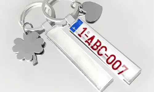 Schlüsselanhänger im Nummernschild-Stil mit Flagge und dekorativen Anhängern