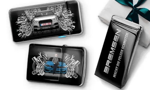 Three automotive-themed items featuring car illustrations and machinery motifs, arranged with a gift box tied with a green ribbon on the side.