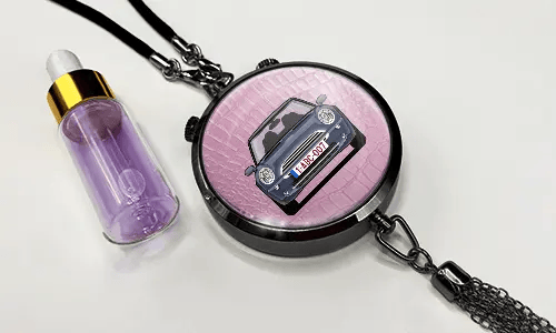 Pendant with pink background and white sports car, next to purple dropper bottle with gold cap