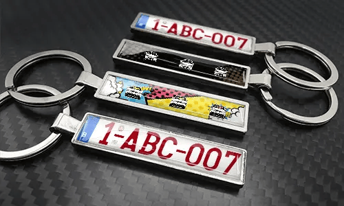 Set di portachiavi in metallo a forma di targa in stile fumetto con design di auto colorate e finitura metallica