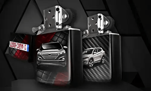 Two metallic lighters with silver SUV designs: one front view on tread background, one side view with carbon texture, small rectangular object in corner