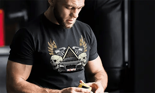 Schwarzes T-Shirt mit Grafik von Auto, Schädeln, Pistolen, goldenen Flügeln und sternförmigem Dreieckshintergrund