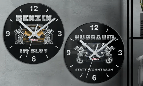 Two black wall clocks with car illustrations and German text: BENZIN IM BLUT and HUBRAUM STATT WOHNTRAUM