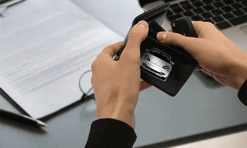 kreditkartenetui carbon mit Autosilouette neben Laptop carbon geldbörse