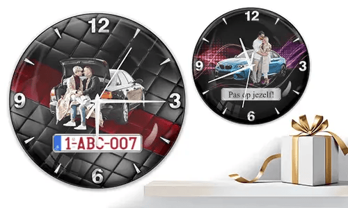Two wall clocks with family and car scenes: left with trunk picnic on quilted background, right with blue sports car and couple over purple wave