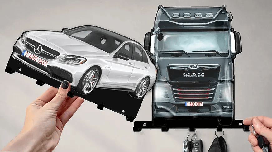 Wall-mounted key holder with detachable white Mercedes-Benz and black MAN truck shapes, each with hooks for keys
